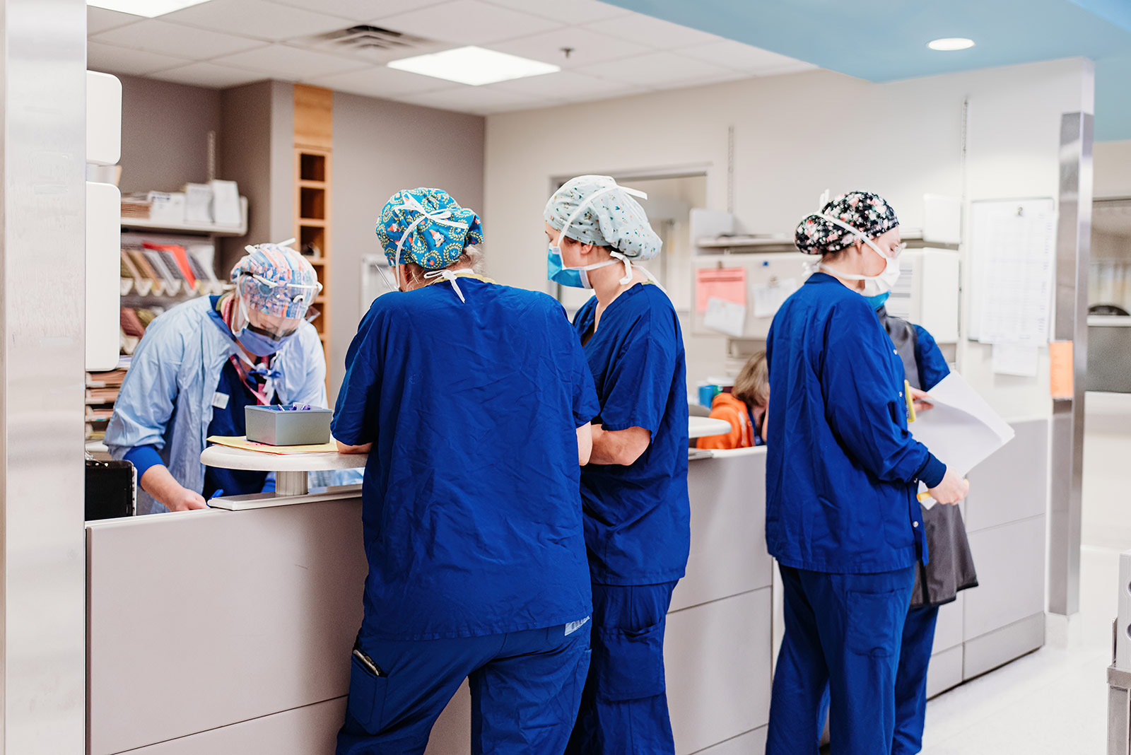 Several people in scrubs in a nursing ward.