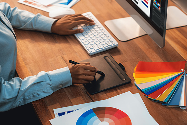 Graphic designer work on computer laptop and with graphic drawing pen.